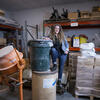 Nichola Kinch leaning against a bucket in a studio space