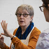 A woman speaking to a Tyler printmaking student.