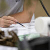 A student holding a pencil and taking notes.