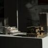 Two architecture building models resting on a white table.