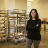 Lauren Sandler stands with her arms crossed in a ceramics studio at Tyler.