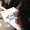 A students hands as they sketch.