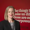 Portrait of Cheryl Carreno in front of a red wall with white words in the background