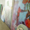 Paintings lined against a wall.