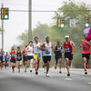 Runners in a marathon racing down an empty street.