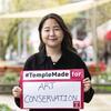 Sera park smiling at the camera and holding a sign that says " #TempleMade for Art Conservation".