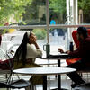 two students sitting at a table by a window