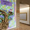 Wall decorated with a tree and post-its inside a dorm buidling