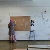 3 students facing away from the camera, drawing on paper
