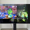 A wide screen showing glitched images of a state legislature meeting overlapping with other found images. 