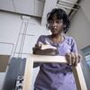 A Tyler architecture student sanding wood.