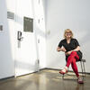 Delaney DeMott sits in a chair in front of a white wall.