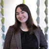 A headshot of Emily Dugan, smiling and looking directly at the camera, with a warm and welcoming expression.