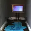 A screen inside a small space with two chairs facing it. They rest on top of a map on the floor.