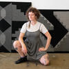 Lena Kolb posing in front of artwork in the studio