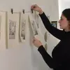 MFA student hangs illustrations on the wall for review