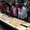 A group of people look at storytelling posters laid out on a table