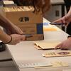 Students looking at files in a box.