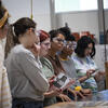 Students wearing safety goggles watching a demonstration in class.