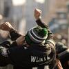 An Eagles sports fan cheers loudly in a large crowd, celebrating with excitement. Surrounded by fellow fans, the atmosphere is electric, filled with team spirit and joy as they revel in the moment.