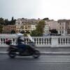 A person driving a motorcycle in Rome.