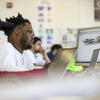 A student is looking at a computer in class, focused on the screen.