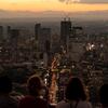 students look out over the skyline of tokyo at sunset