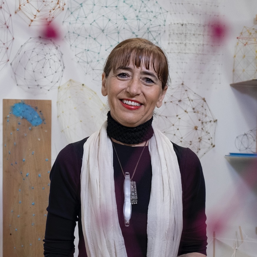 Sonja Bijelic standing in a studio space, looking at the camera, surrounded by work.